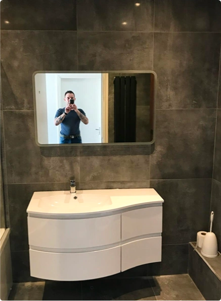 A man taking a selfie in the mirror, capturing his reflection with a smartphone
